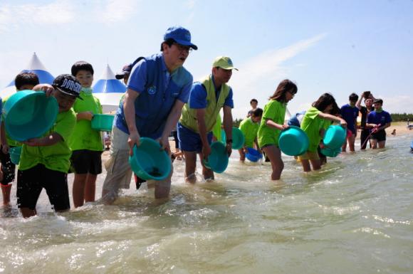 포스코켐텍이 13일 오후 지역 어린이 100명을 초청해 푸른꿈 환경학교를 열고 넙치, 강도다리 등 치어 4만5천마리를 영일만 일대에 방류했다. 조봉래 사장(앞줄 외쪽 두번째)이 어린이들과 치어를 방류하고 있다.