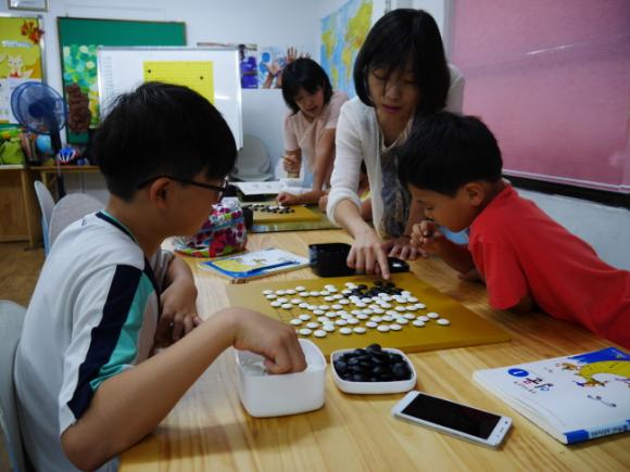 포항시 연고의 포스코켐텍 프로바둑 선수단이 지역 어린이들을 대상으로 재능기부 활동을 펼치고 있다. 여류국수 타이틀 보유자인 이영신 5단(여자 바둑팀 감독, 사진 앞쪽)과 김혜민 6단(사진 뒤쪽) 이 바둑교육을 하고 있는 모습